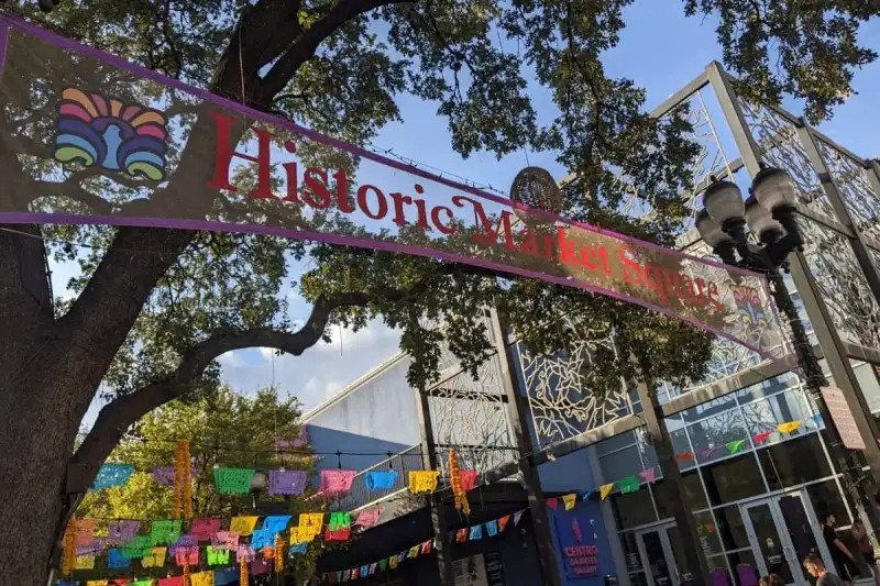 Outdoor plaza with festive papel picado banners fluttering over Historic Market Square in San Antonio
