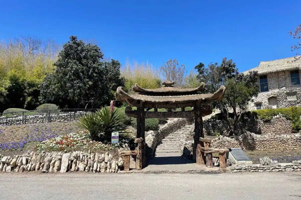 Stone arch bridge over koi ponds and lush greenery at the Japanese Tea Garden in San Antonio TX