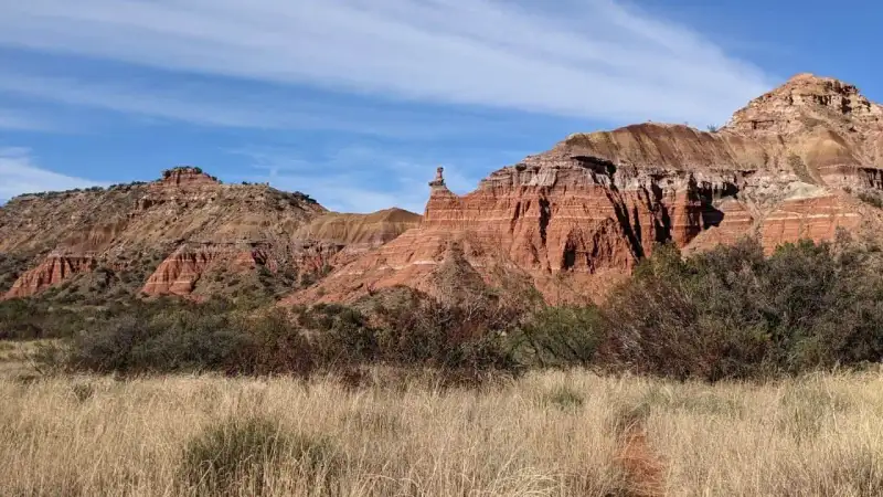 Panoramic scenic view of Palo Duro Canyon showing vibrant red clay sedimentary layers and rugged Panhandle terrain