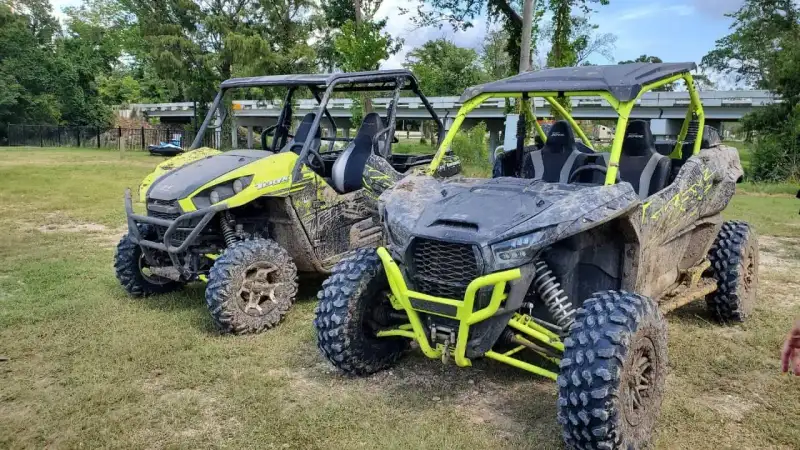 Riders on four-wheel ATVs and side-by-sides traversing mud bogs and sandy trails at Xtreme Off Road Park and Beach in Crosby Texas