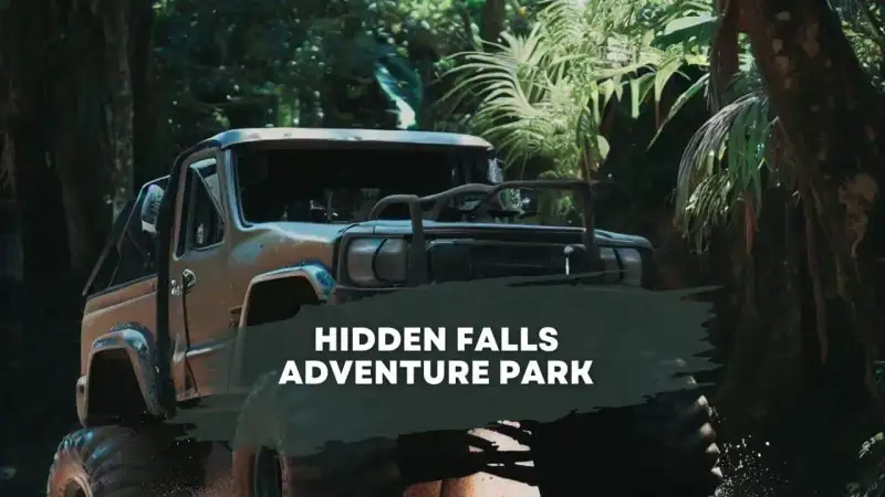 Modified four-wheel-drive vehicle navigating rocky limestone ledges at Hidden Falls Adventure Park