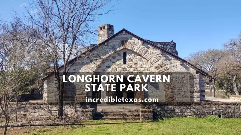 Illuminated underground limestone corridor and smooth rock formations inside Longhorn Cavern