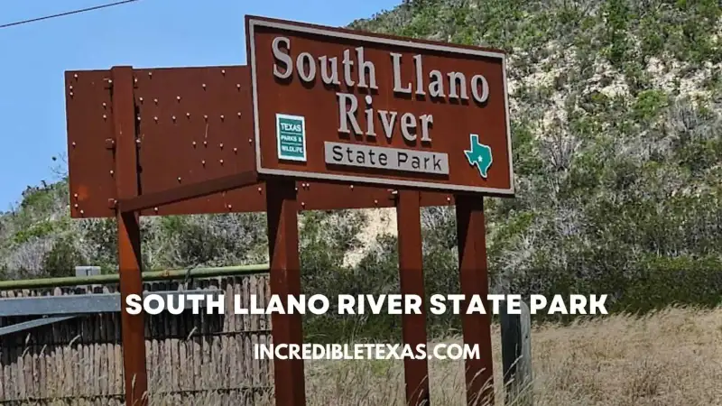 South Llano River flowing gently past limestone canyon bluffs and autumn pecan trees in Junction Texas