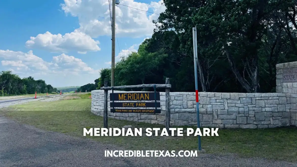 The historic Civilian Conservation Corps limestone refectory standing beside the calm waters of Lake Meridian in Meridian State Park Texas