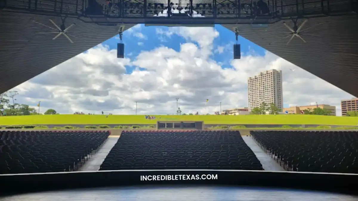 Covered stage canopy and grassy hillside audience lawn at Miller Outdoor Theatre in Houston