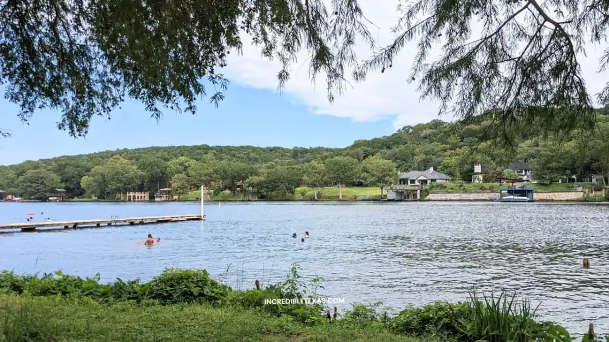 Motorboat cruising along the limestone bluffs and calm waters of Lake Austin Texas