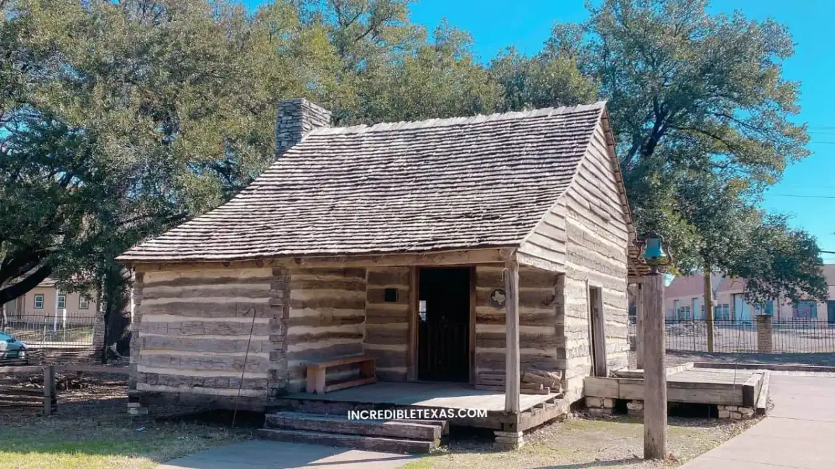 Historic pioneer buildings and green grounds at Dallas Heritage Village in Old City Park