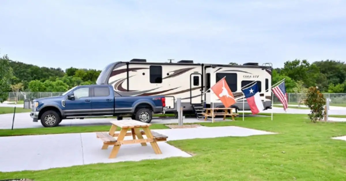 Aerial view of paved RV sites, clubhouse, and swimming pool at Eric & Jay's RV Resort in Houston