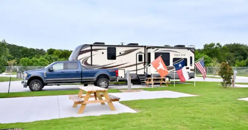 Aerial view of paved RV sites, clubhouse, and swimming pool at Eric & Jay's RV Resort in Houston