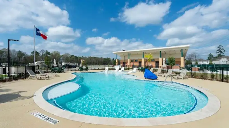 Paved pull-through RV pads with full hookups and landscaped pine trees at Laurel Springs RV Resort in Kingwood