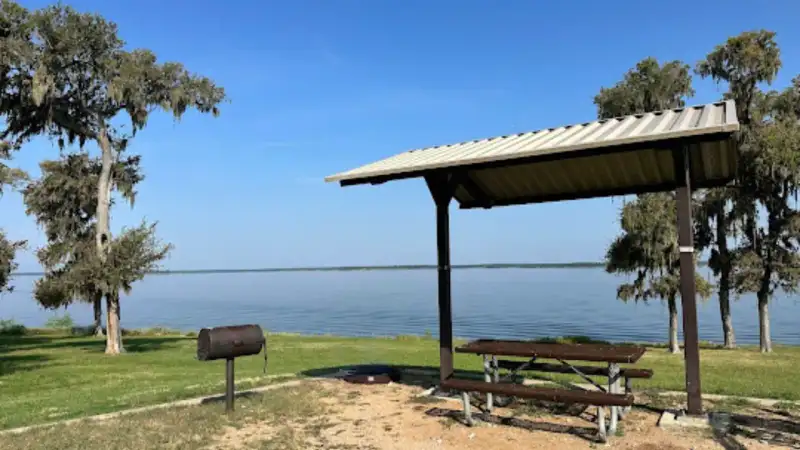 Shaded shoreline campsite and boat ramp view across Lake Somerville in Central Texas