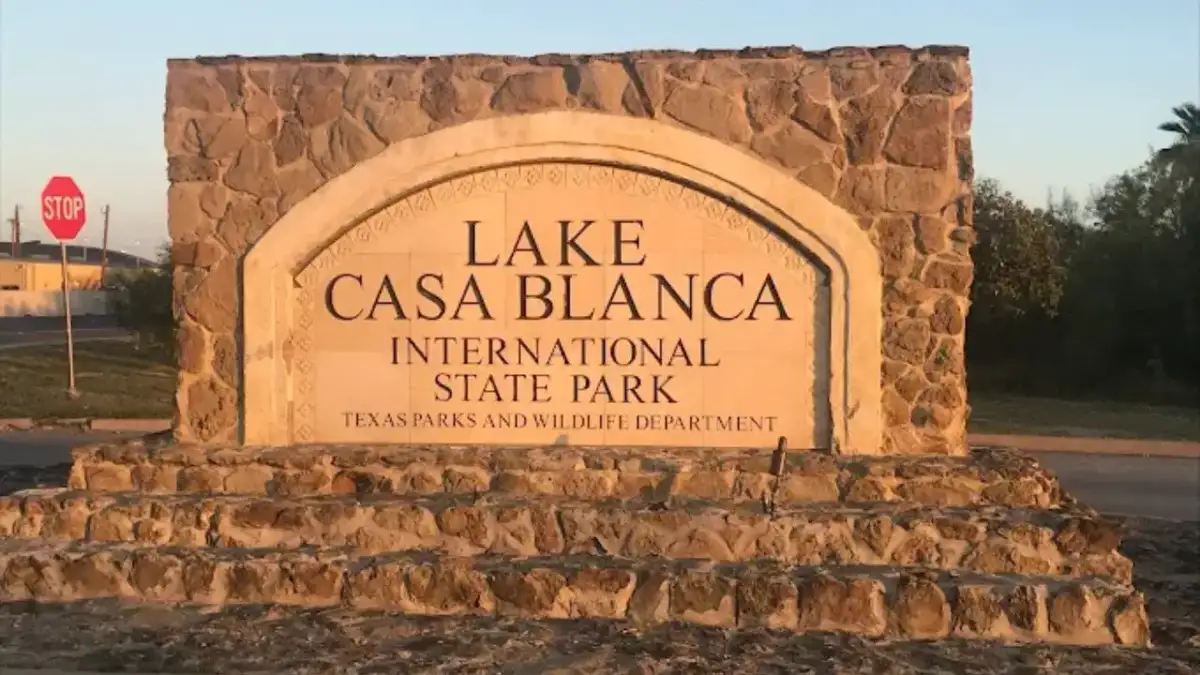 Calm lake waters and shaded mesquite picnic shoreline at Lake Casa Blanca State Park