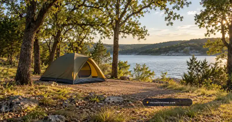Tent beside a calm lake beneath mature oak trees at a North Texas campground