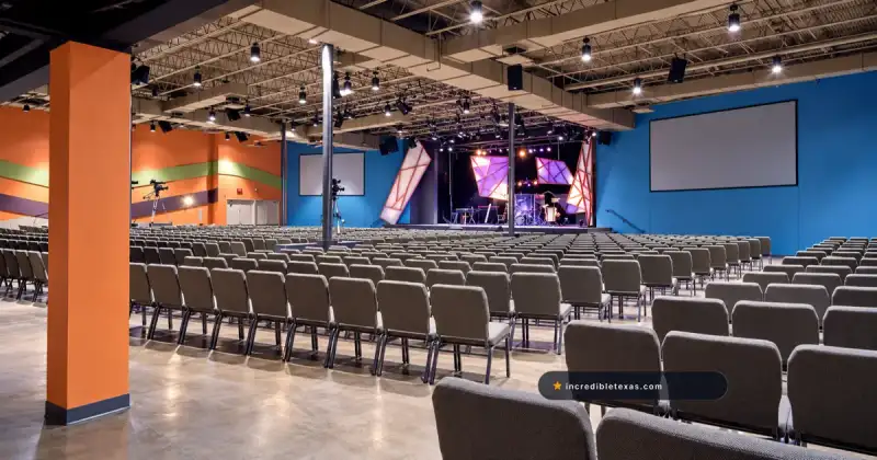 Rows of gray auditorium seats face the worship stage at Fellowship Church Dallas on Ross Avenue