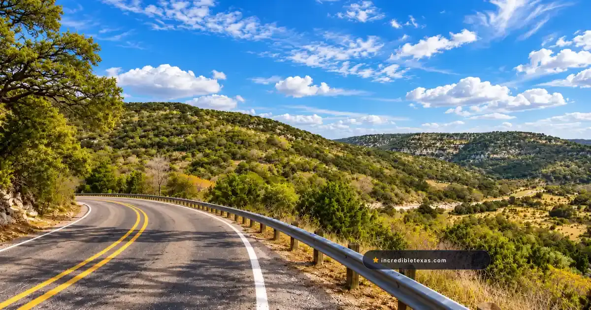 Two-lane ranch road curves through scrubby limestone hills on the Twisted Sisters loop