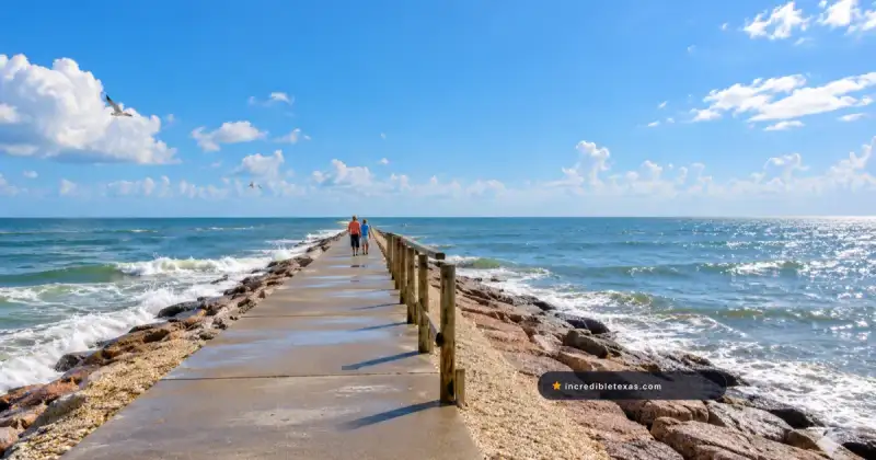Visitors walk the concrete jetty at Surfside Beach near Freeport