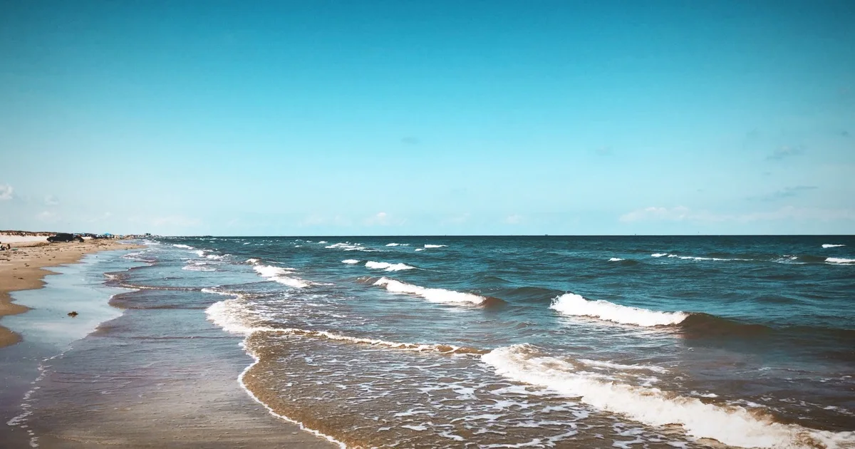 Mustang Island State Park's Gulf shoreline with surf and vehicles on the beach