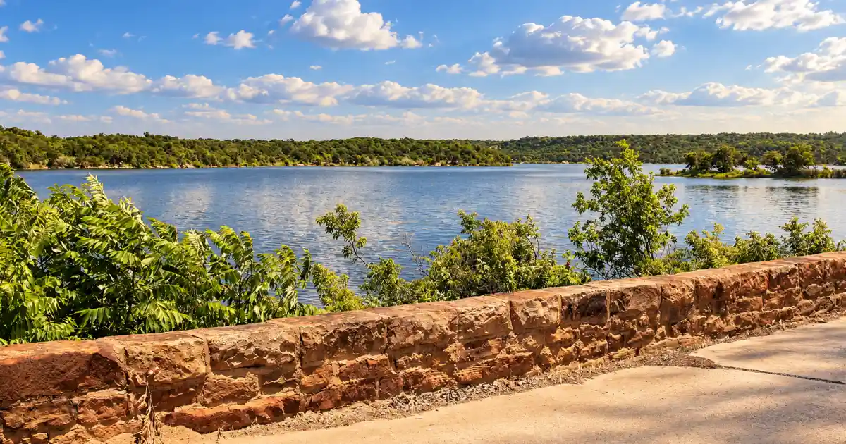Lake Mineral Wells and its wooded shoreline from the stone overlook near the spillway