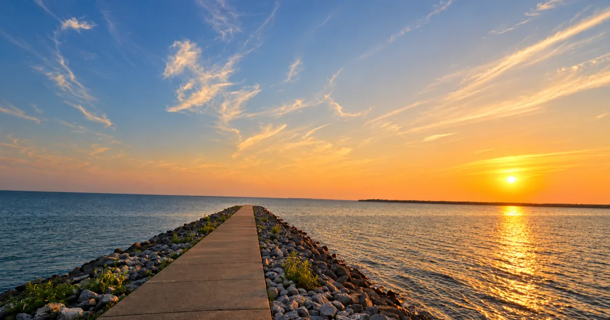 Long concrete jetty reaching into Ray Roberts Lake at sunset