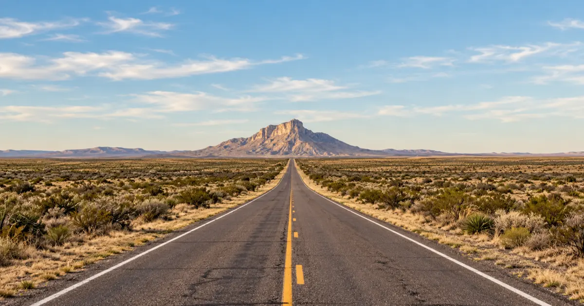 Texas Highway 54 runs straight across desert scrub toward El Capitan in the Guadalupe Mountains.