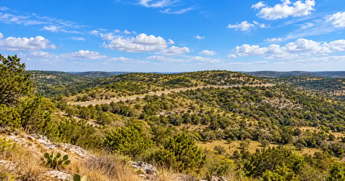 Ranch Road 337 crosses scrub-covered limestone hills on the Twisted Sisters loop.