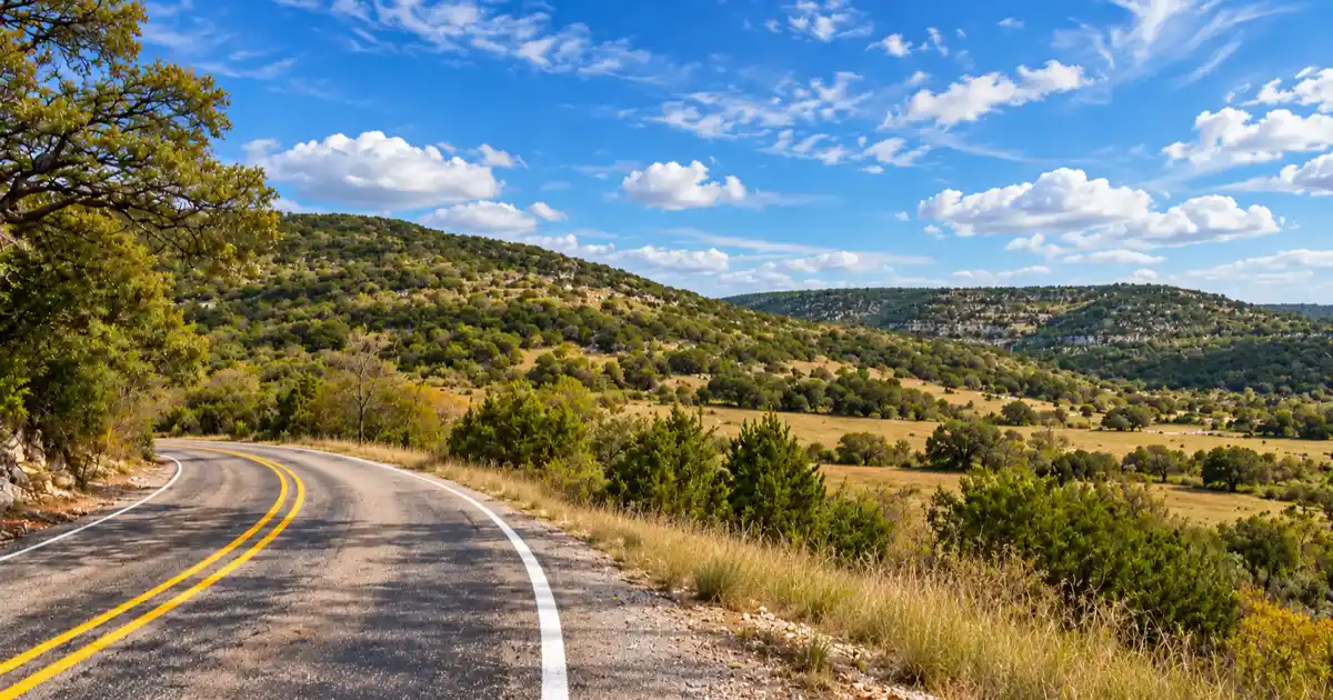 Open ranch grassland and low limestone ridges line Ranch Road 336.