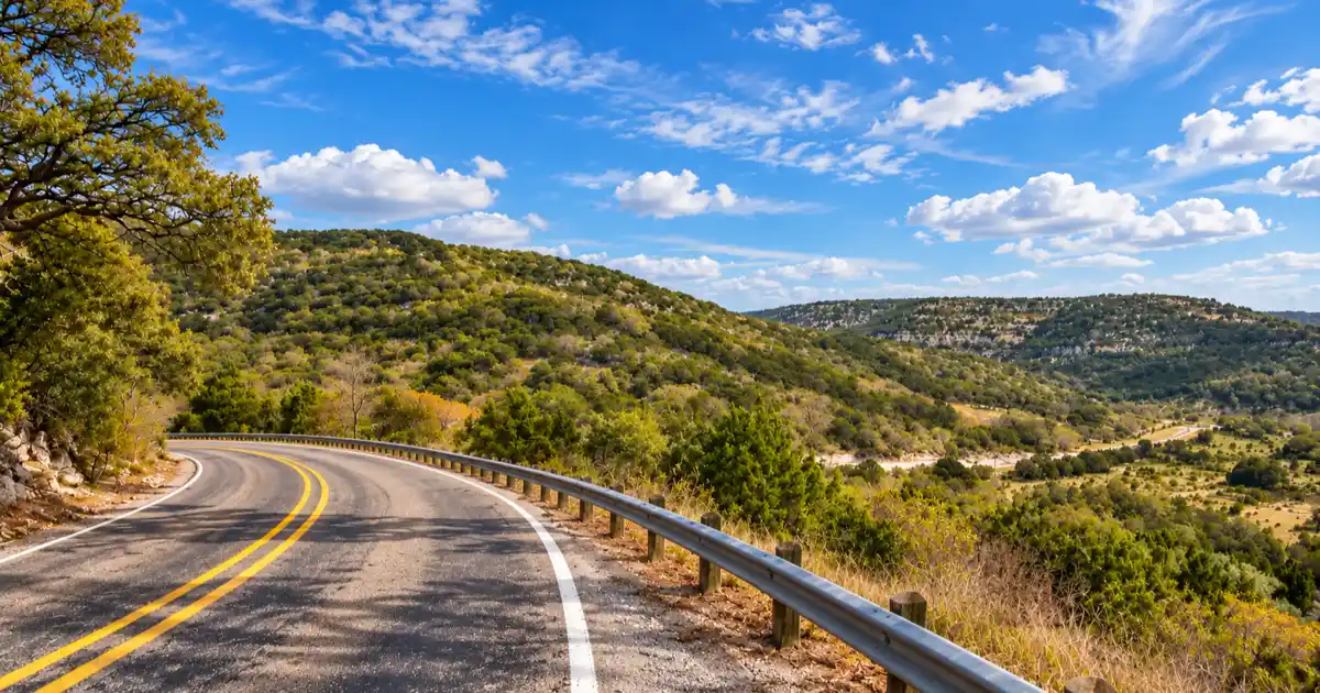 A narrow ranch road bends past juniper and low limestone hills on the Twisted Sisters loop.