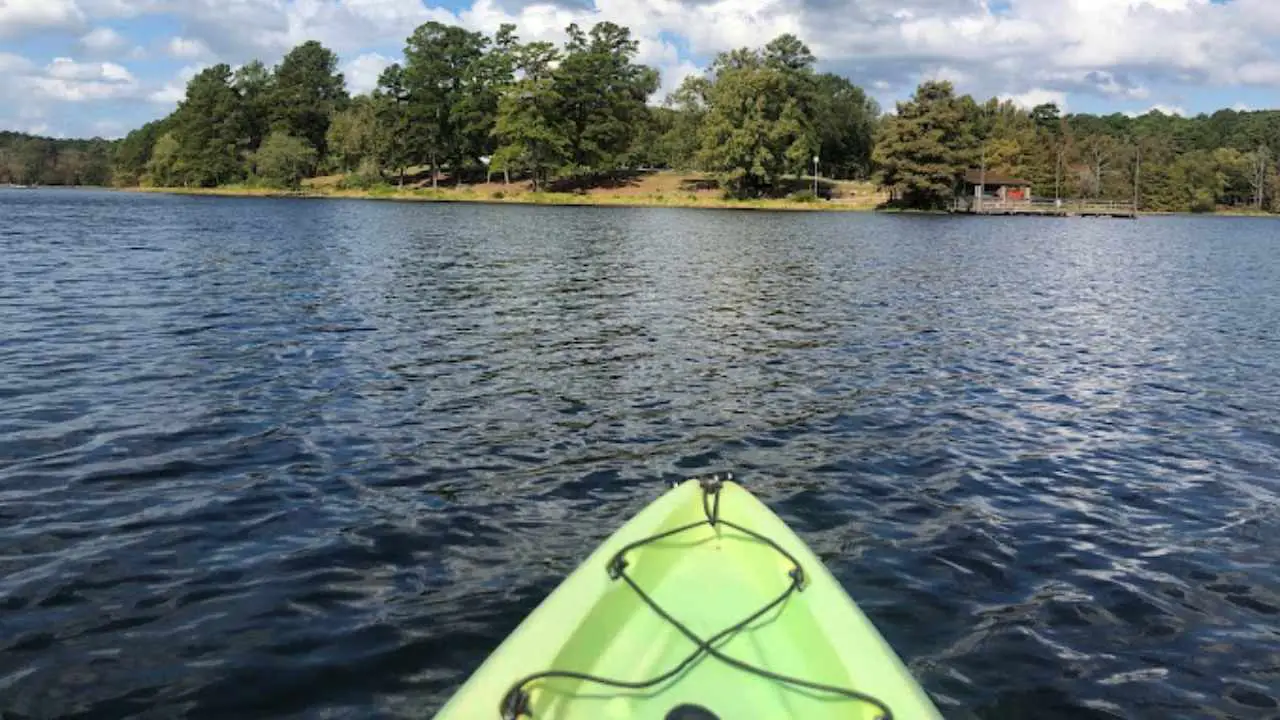 Visitors enjoying a peaceful kayaking session on the calm, clear waters of a Texas State Park lake.