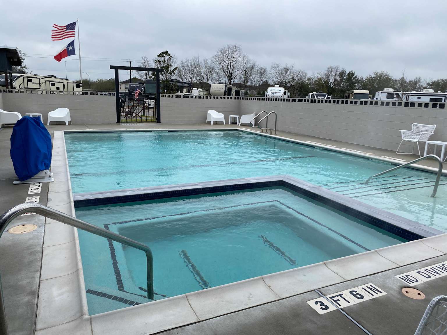 Outdoor swimming pool and hot tub area at Eric & Jay's RV Resort in Pearland, Texas, showcasing a clean and inviting amenity for guests
