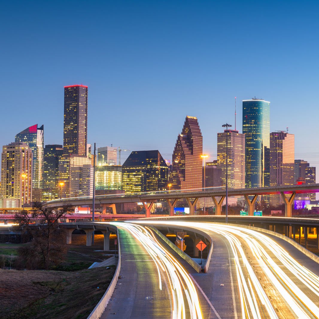 Houston downtown skyline at twilight with highway light trails, showcasing the city's urban landscape and nearby attractions for RV travelers